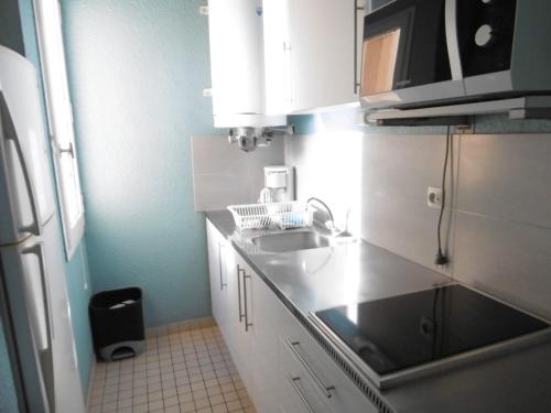 une cuisine avec un évier et un plan de travail dans l'établissement T2 Confortable - 4/5 Pers - Proche Plage Grazel - Parking Privé - FR-1-796-54, à Gruissan