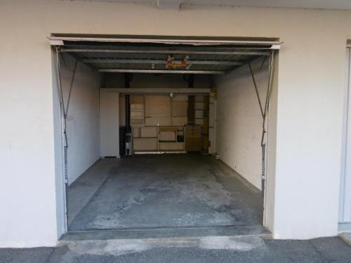 un garage vide avec la porte ouverte dans l'établissement Appartement T2 moderne avec piscines, garage et proche plage - Gruissan - FR-1-796-43, à Gruissan