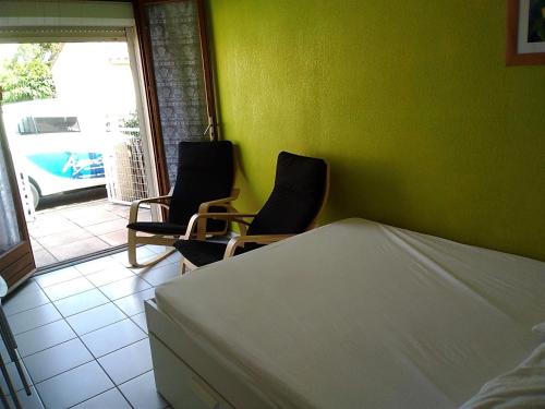 - une chambre avec deux chaises, un lit et une fenêtre dans l'établissement Villa 6 pers avec Piscine, Accès direct Plage & Proximité Commerces à Gruissan - FR-1-796-69, à Gruissan