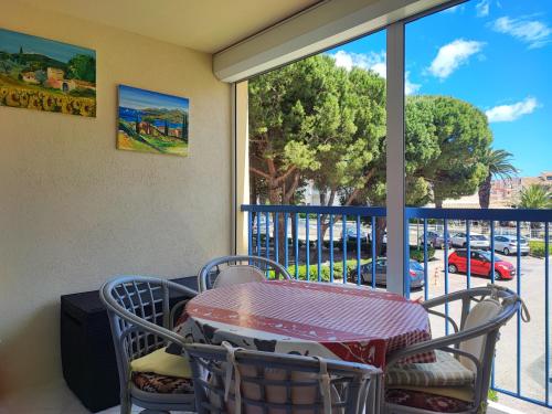 d'une table et de chaises sur un balcon avec vue sur la rue. dans l'établissement Studio spacieux à Gruissan - Parking - Vue port - Proche plage - FR-1-796-29, à Gruissan