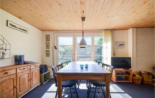 a dining room with a wooden table and chairs at Holiday Home Østerskovvej Grenaa Xii in Grenå