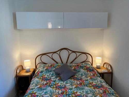 un lit dans une chambre avec deux tables de nuit et deux lampes dans l'établissement Direct Plage, Piscine et Parking - Confort Moderne pour 4 Pers - FR-1-796-37, à Gruissan