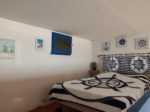 une chambre avec un lit avec une couette noire et blanche dans l'établissement **Gruissan - T2 Cabine Mezzanine - Côté Village - 6 pers - Parking Privé - Proche Plages** - FR-1-796-63, à Gruissan