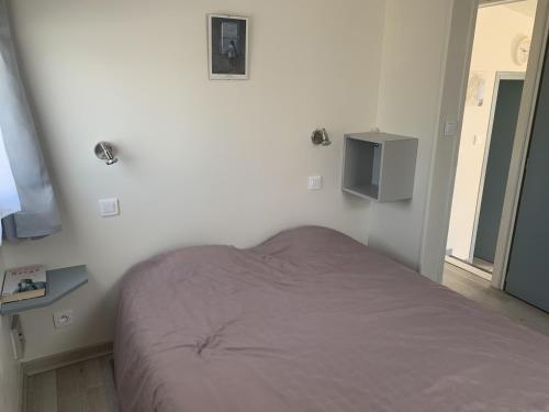 une chambre avec un lit et une télévision au mur dans l'établissement Gruissan, T3 climatisé sur plage, terrasse, 4 pers - FR-1-796-68, à Gruissan