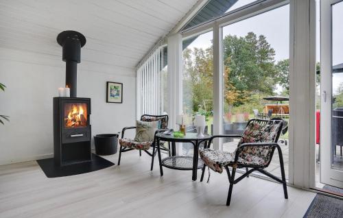 a living room with a fireplace and a table and chairs at Cozy Home In Glesborg With Wifi in Glesborg