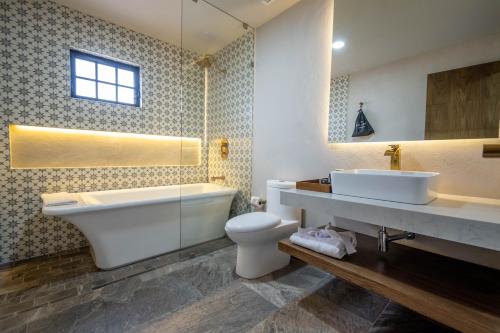 a bathroom with a tub and a toilet and a sink at Hotel Boutique Divino Sol in León