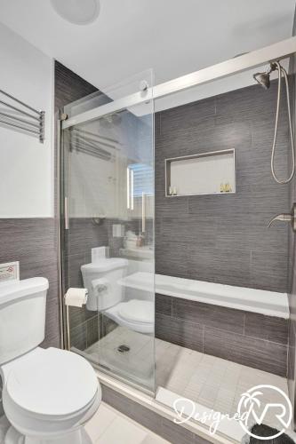 a bathroom with a toilet and a glass shower at Modern condo wpool patio in Deerfield Beach