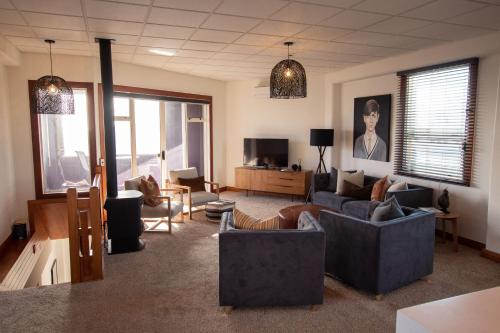 a living room with couches and chairs and a tv at Stay Central in New Plymouth