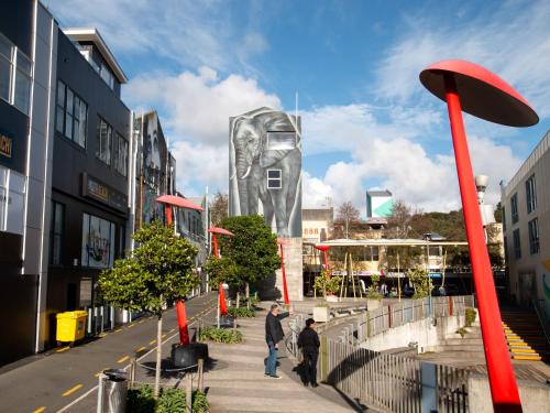 two people walking down a street with a statue at Stay Central in New Plymouth
