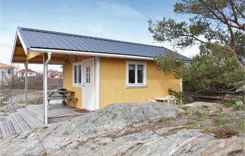 a small yellow house with a wooden porch at 1 Bedroom Stunning Home In Vrångö in Vrångö