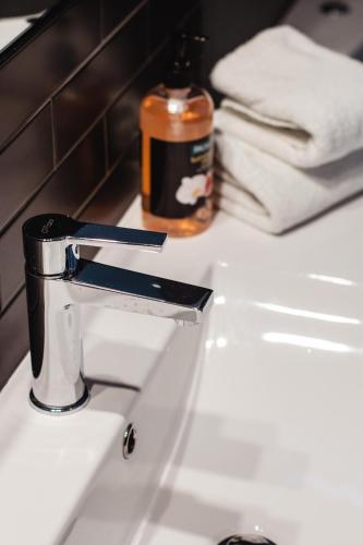 a bathroom sink with aaucet and a soap bottle at Stay Central in New Plymouth