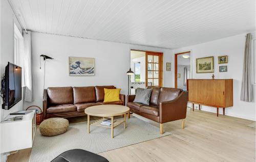 a living room with a couch and a table at Holiday Home Slivsø Ii in Diernæs