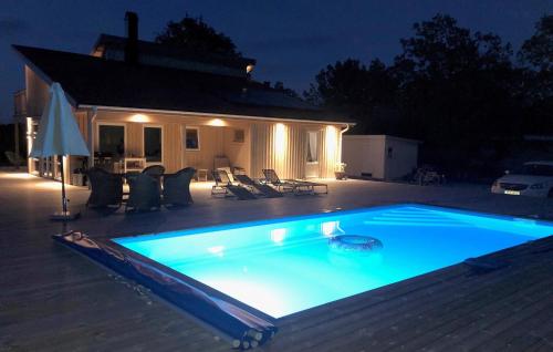 a swimming pool at night in front of a house at Awesome Home In Löttorp With Sauna in Löttorp
