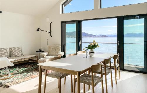 a living room with a table and chairs and a large window at Beautiful Home In Giske With Jacuzzi in Ytterland