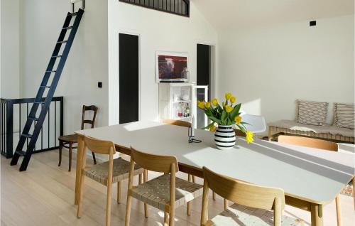a dining room with a white table and chairs at Beautiful Home In Giske With Jacuzzi in Ytterland