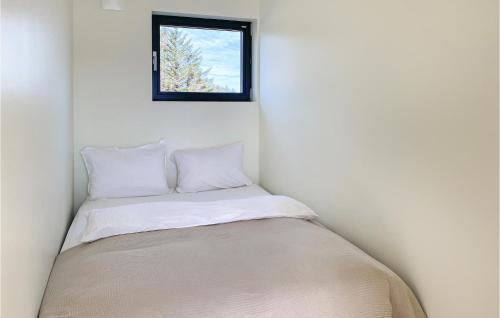 a bed in a corner of a room with a window at Beautiful Home In Giske With Jacuzzi in Ytterland