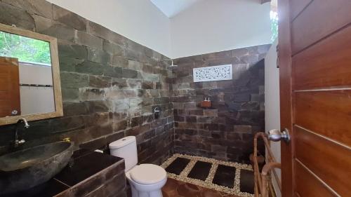 a bathroom with a sink and a toilet at Frangipani Inn & Restaurant in Seraya