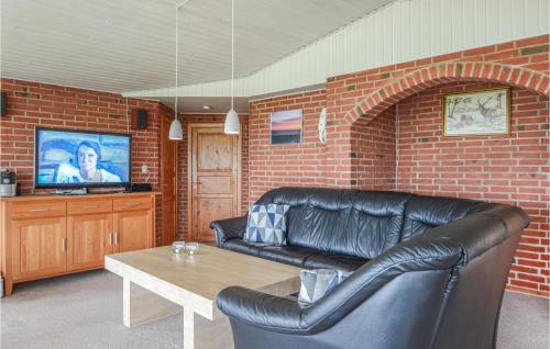 a living room with a leather couch and a table at Holiday Home Æ Skovbryn Hejls Ii in Hejls