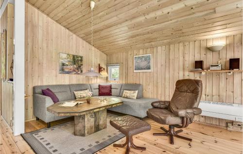 a living room with a couch and a table at Holiday Home Valmuevej Tranekær Denm in Skattebølle