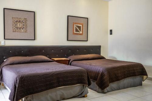 two beds sitting next to each other in a room at Hotel María de la Luz in Valladolid