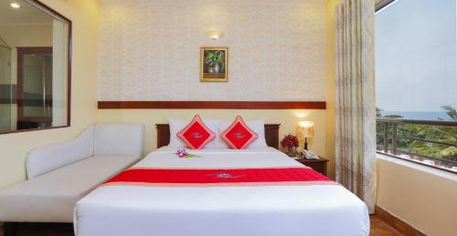 a bedroom with a bed and a couch and a window at Kim Hoa Resort in Phú Quốc