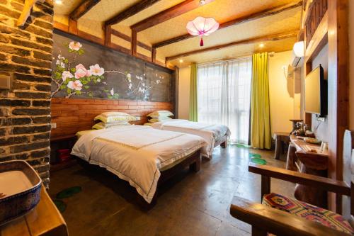 a bedroom with three beds and a wall with flowers at Butterfly Flowers Inn in Zhangjiajie