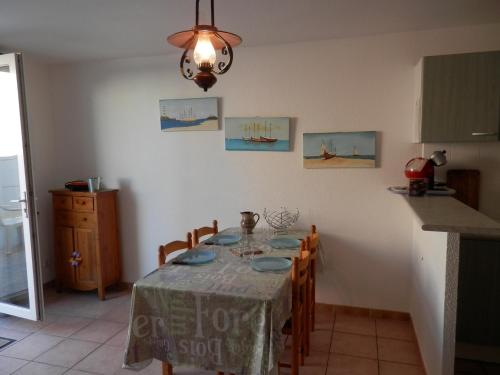 une salle à manger avec une table et une cuisine dans l'établissement Villa Climatisée à Gruissan, Proche Plage Grazel, 6 Pers, Parking Privé, Terrasse, Équipée - FR-1-796-70, à Gruissan