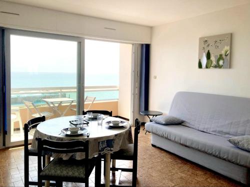 un salon avec une table et un canapé dans l'établissement Studio Cabine Front de Mer avec Terrasse et Parking Privé - 4 Pers - FR-1-794-152, à Canet