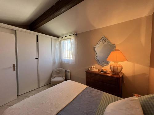 une chambre avec un lit, une lampe et une chaise dans l'établissement Villa T3 climatisée avec WIFI, proche plage, 5 pers - FR-1-81-620, au Barcarès