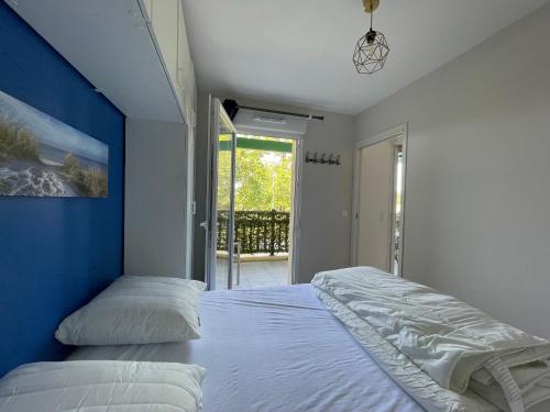 une chambre avec deux lits et un mur bleu dans l'établissement Charmant T2 proche plages et commerces avec terrasse à Vieux-Boucau - FR-1-239-1072, à Vieux-Boucau-les-Bains