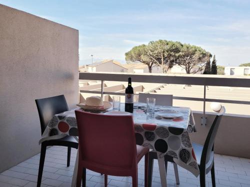 - une table avec une bouteille de vin sur le balcon dans l'établissement Canet-en-Roussillon - Studio cabine 4 pers. - Accès plage direct, Parking, Secteur Thalasso - FR-1-794-151, à Canet