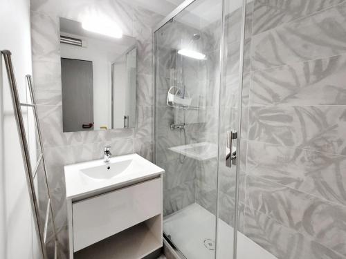 une salle de bain blanche avec une douche et un lavabo dans l'établissement Canet-en-Roussillon - Studio cabine 4 pers. - Accès plage direct, Parking, Secteur Thalasso - FR-1-794-151, à Canet
