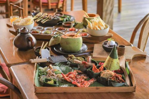 a table with a buffet of food on it at Amnaya Resort Kuta in Kuta