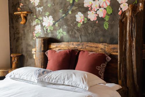 a bed with red and white pillows and a floral wall at Butterfly Flowers Inn in Zhangjiajie