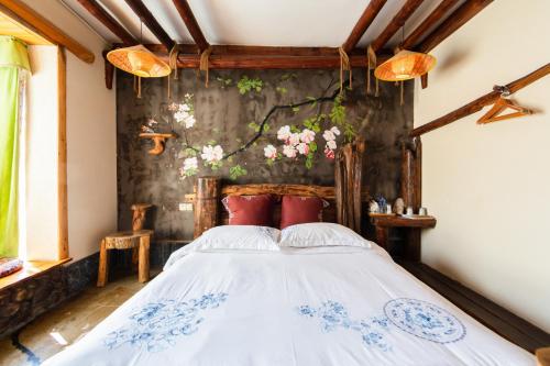 a bedroom with a white bed with red pillows at Butterfly Flowers Inn in Zhangjiajie