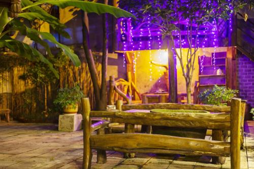 two wooden benches in a courtyard with purple lights at Butterfly Flowers Inn in Zhangjiajie