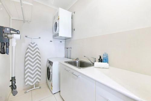 una cucina con lavello e lavatrice di Larrakeyah Luxury - Penthouse Getaway with Views a Darwin