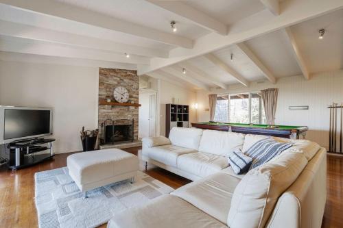 a living room with a couch and a pool table at Port Philip Panorama - Bayview Retreat and Pool Bliss in Mount Martha