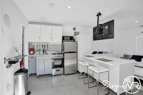 a kitchen with stainless steel appliances and white cabinets at UnitA SeaI Private Studio near Deerfield Beach in Deerfield Beach