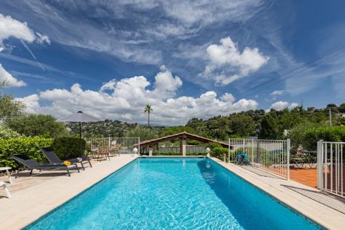 - une piscine avec des chaises et un ciel bleu dans l'établissement LB Vacation Rentals I Villa With Pool, Terrace, BBQ, Close To Golfs & Tennis, à Mougins