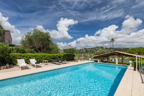une grande piscine avec des chaises dans l'établissement LB Vacation Rentals I Villa With Pool, Terrace, BBQ, Close To Golfs & Tennis, à Mougins