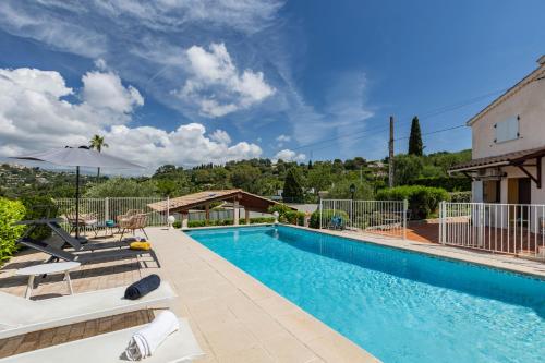 une piscine avec des chaises et un parasol dans l'établissement LB Vacation Rentals I Villa With Pool, Terrace, BBQ, Close To Golfs & Tennis, à Mougins