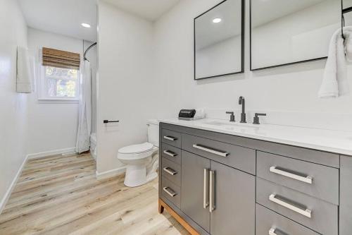 a white bathroom with a toilet and a sink at Palmer Pointe Heights Colorado Adventure Home Base WiFi, AC & Pets in Colorado Springs