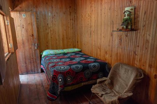a room with a bed in a wooden room at Cardisch in Santa Rosa de Cabal