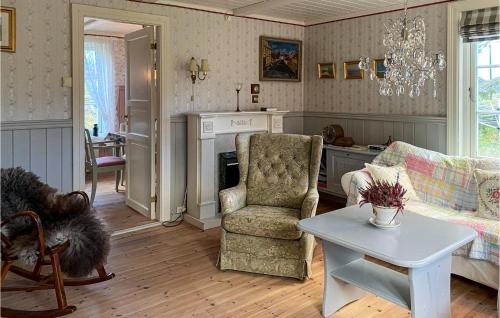 a living room with a couch and a chair and a table at Pet Friendly Home In Smøla With Wifi in Smøla