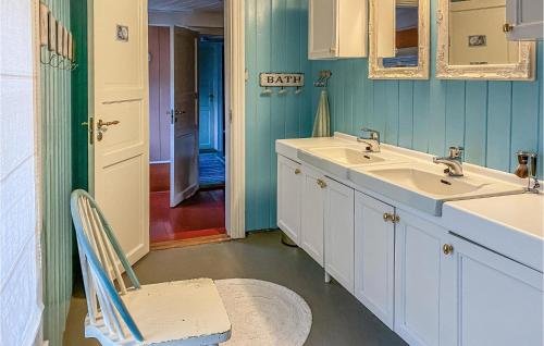 a bathroom with two sinks and a chair in it at Pet Friendly Home In Smøla With Wifi in Smøla