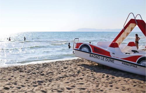a boat on the beach with people in the water at Maremma in Principina a Mare