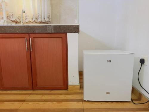 a white refrigerator in a kitchen next to a counter at 207 in Hikkaduwa