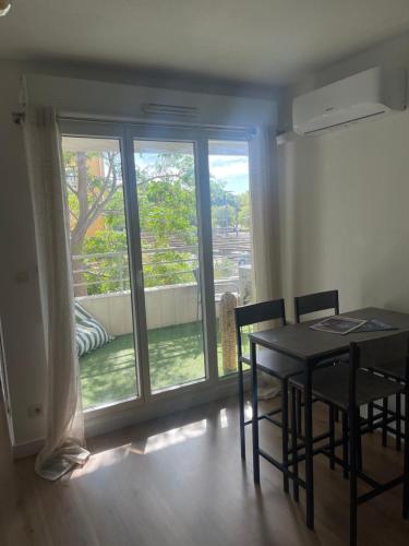 une salle à manger avec une table et des chaises et une fenêtre dans l'établissement Escapade en Camargue, à Port-Saint-Louis-du-Rhône
