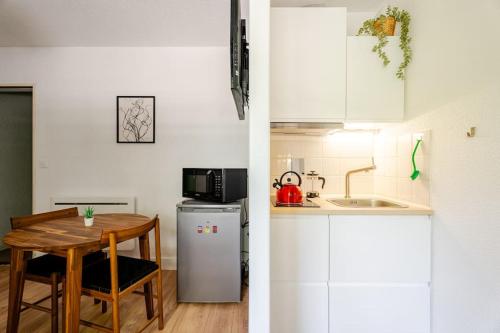 une petite cuisine avec une table et un micro-ondes dans l'établissement Studio Elie, à Grenoble